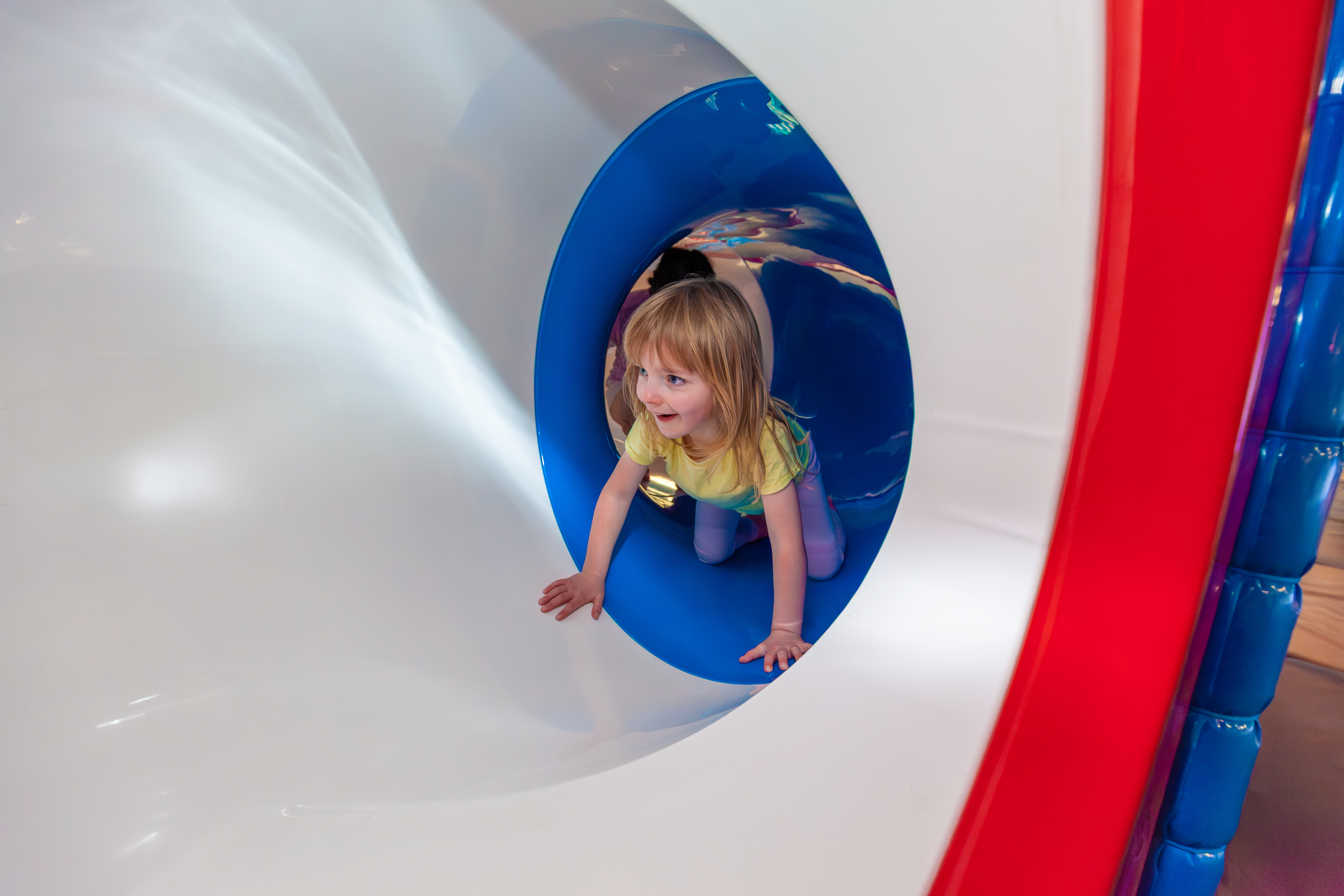 An image of a girl in a slide in an indoor soft play centre